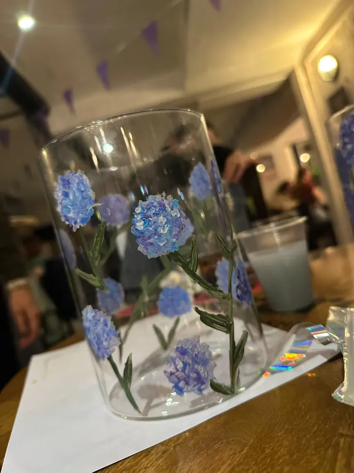 Close-up of a glass vase painted with blue hydrangeas