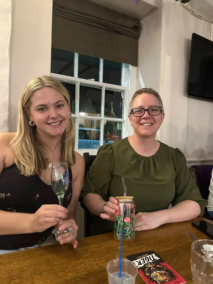 Two guests smiling with the champagne flute and tumbler they have just painted